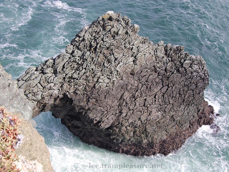 photo showing a tower of rocks in the ocean